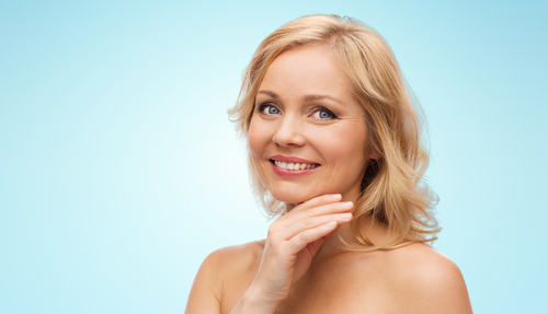 smiling middle aged woman with bare shoulders touching face-img-blog