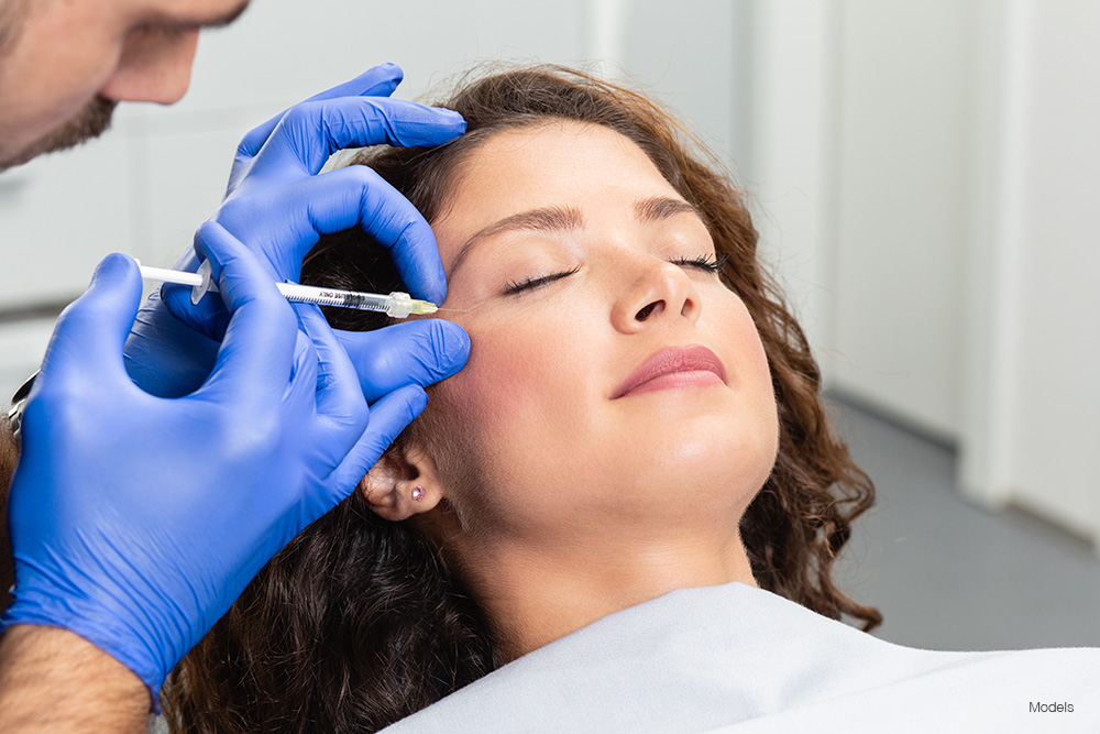 woman getting an injection to her crows feet