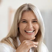 Smiling woman with long gray hair wearing white sweater in bright professional portrait - procedure in Newport Beach, CA