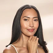 Woman with clear skin and natural makeup posing with hands clasped near chin in beauty portrait - procedure in Newport Beach, CA