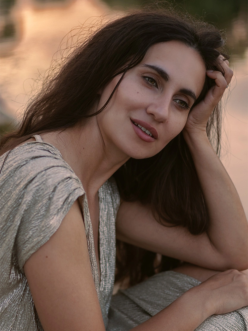 Young woman with long dark hair resting hand on head, wearing casual light-colored top outdoors - C02 Laser in Newport Beach, CA
