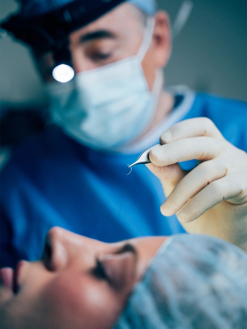 Dr Ackerman MD performing procedure on patient while wearing surgical mask and protective equipment - Eyelid surgery in Newport Beach, CA