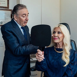 Dr Boris M Ackerman MD examining woman's neck during consultation for cosmetic surgery procedure in medical office - Deep plane facelift in Newport Beach, CA