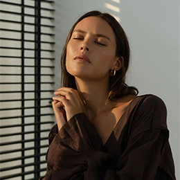 Woman with smooth skin in natural sunlight demonstrating results of Botox and wrinkle relaxer treatments - Liquid rhinoplasty in Newport Beach, CA