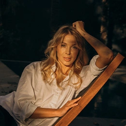 Woman with glowing skin relaxing outdoors in golden hour light after skincare treatment - Microneedling in Newport Beach, CA