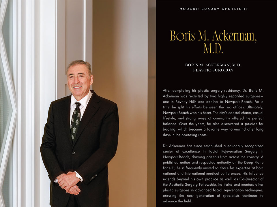 Boris Ackerman standing in formal attire next to informational plaque about his medical practice and board certifications