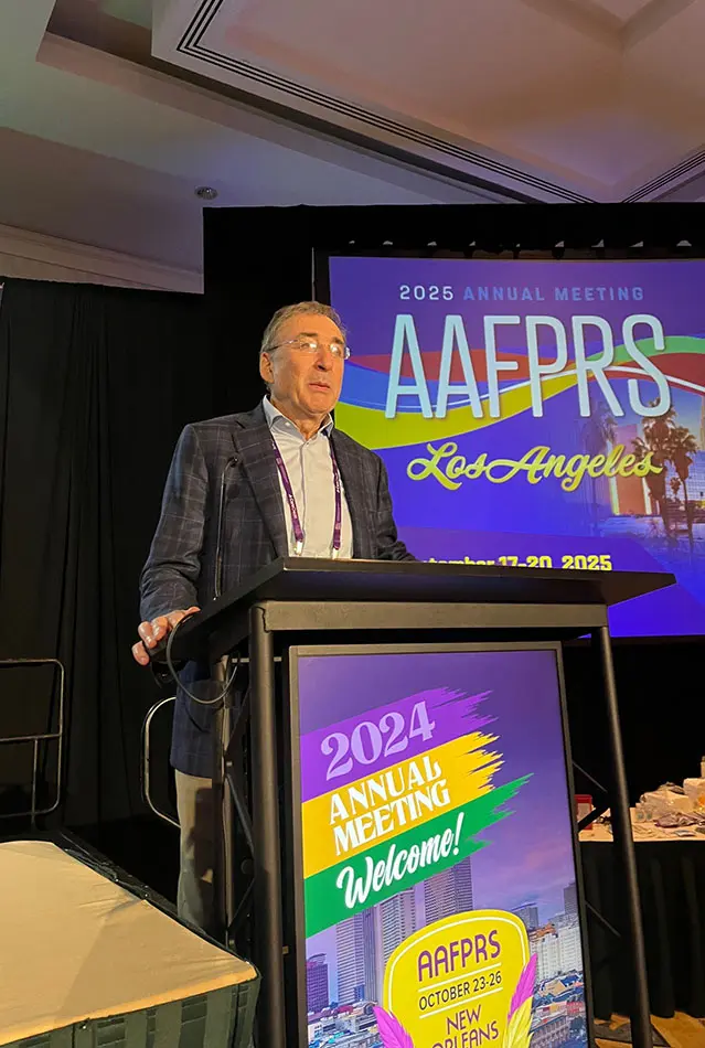 Dr Boris M Ackerman MD presenting at AAEFRS 2024 Annual Meeting podium with colorful event branding display
