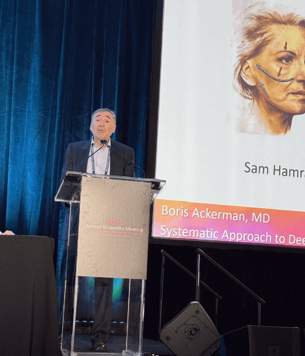 Dr Boris M Ackerman MD presenting at medical conference podium with projection screen showing physician headshot and name