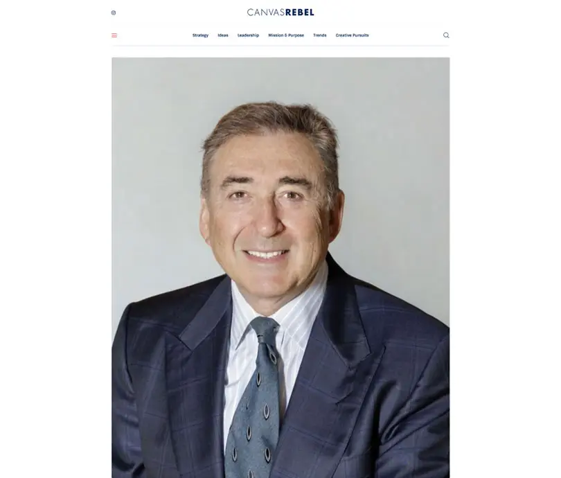 Professional businessman in navy suit and blue tie smiling at camera against neutral background