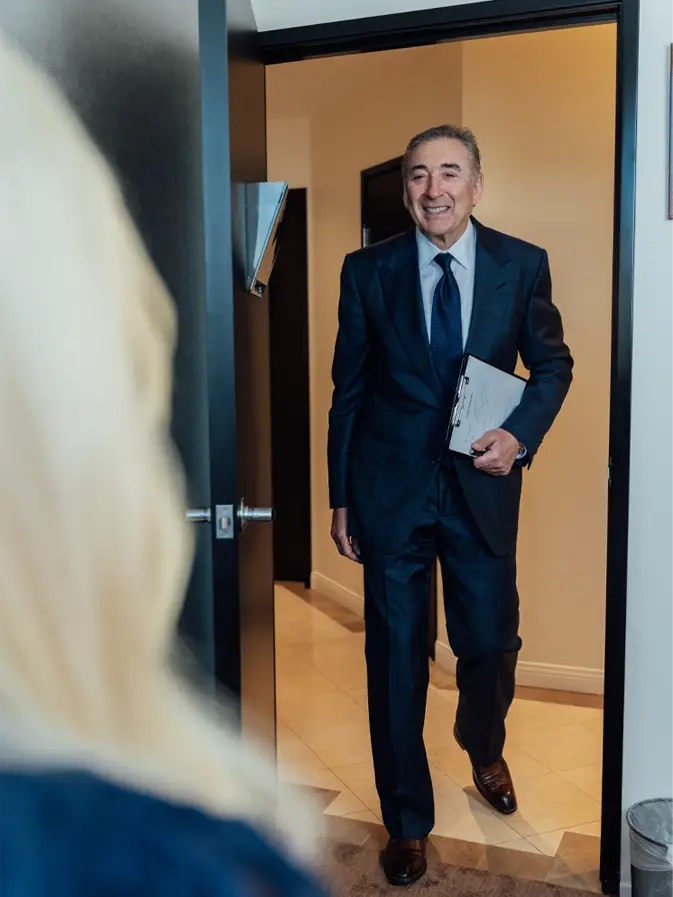 Boris M. Ackerman, MD entering office doorway in formal suit carrying documents - Frist step in Newport Beach, CA