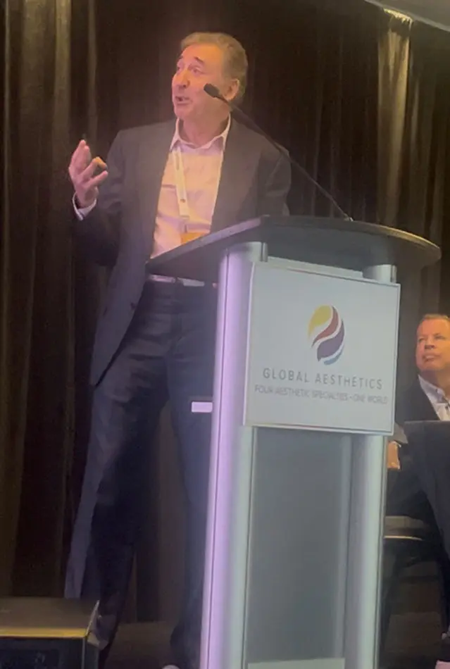 Dr Boris M Ackerman MD presenting at podium with microphone during lecture event