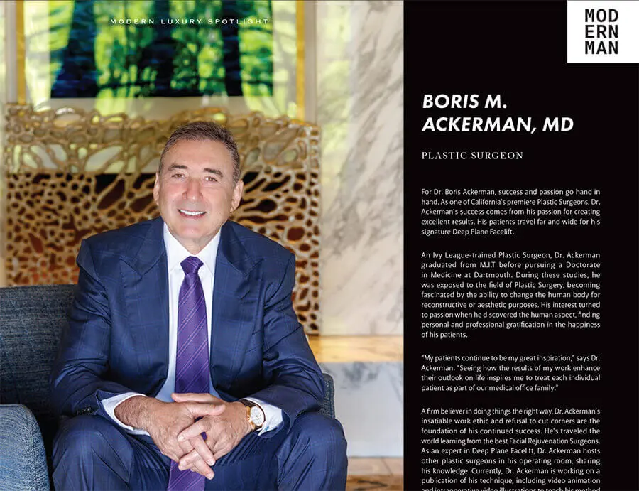 Professional headshot of Boris M. Ackerman, MD in navy suit seated in modern office with abstract art background