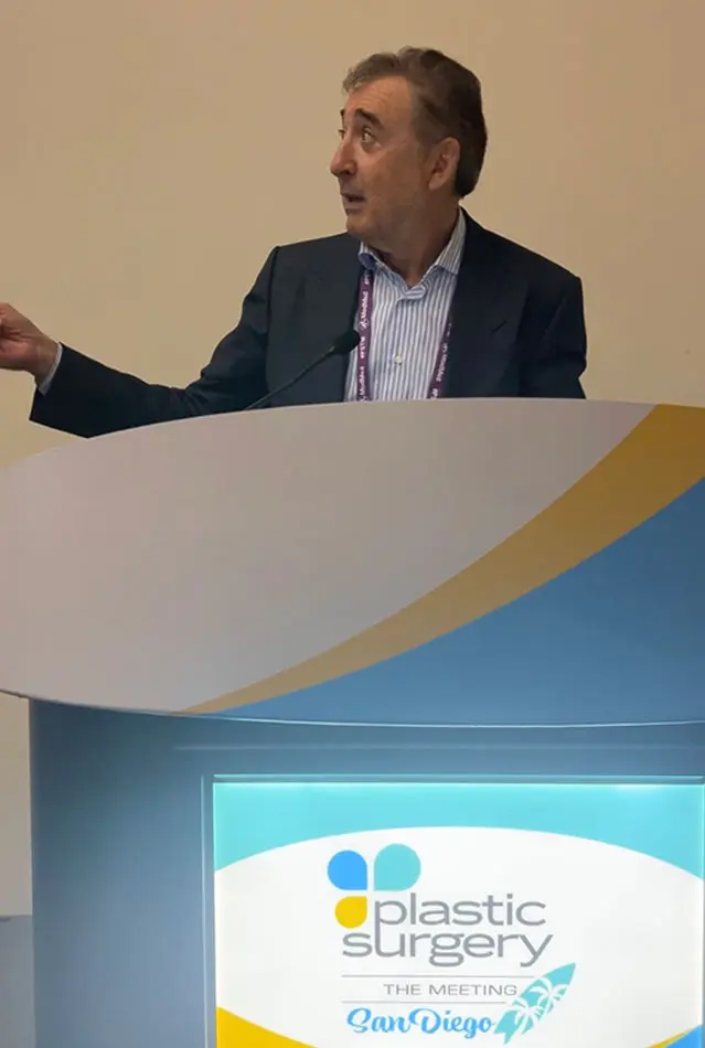 Dr Boris M Ackerman MD presenting at Plastic Surgery Congress podium with blue and gold branding