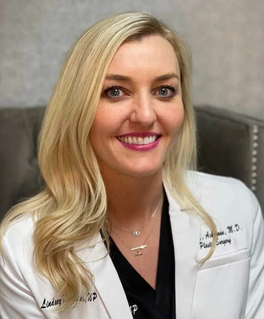 Lindsey healthcare professional in white coat smiling at camera in medical office setting