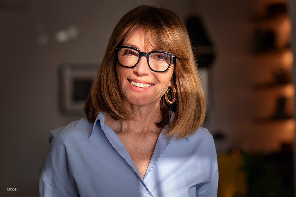 Mature woman with glasses in a blue shirt