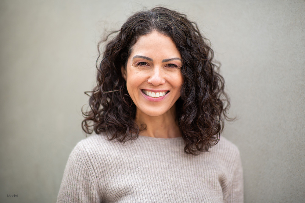 mature woman in a gray sweater with curly hair